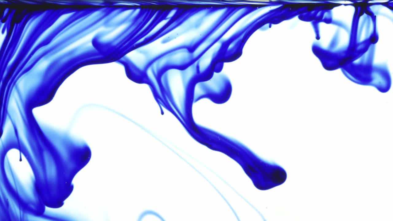 Colorful chemical liquids mix and swirl in water, forming smooth abstract patterns and organic shapes