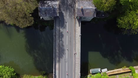 Top-down-aerial-of-a-road-bridge-with-traffic-cones-in-the-middle-of-the-road,-toll-houses-on-edge