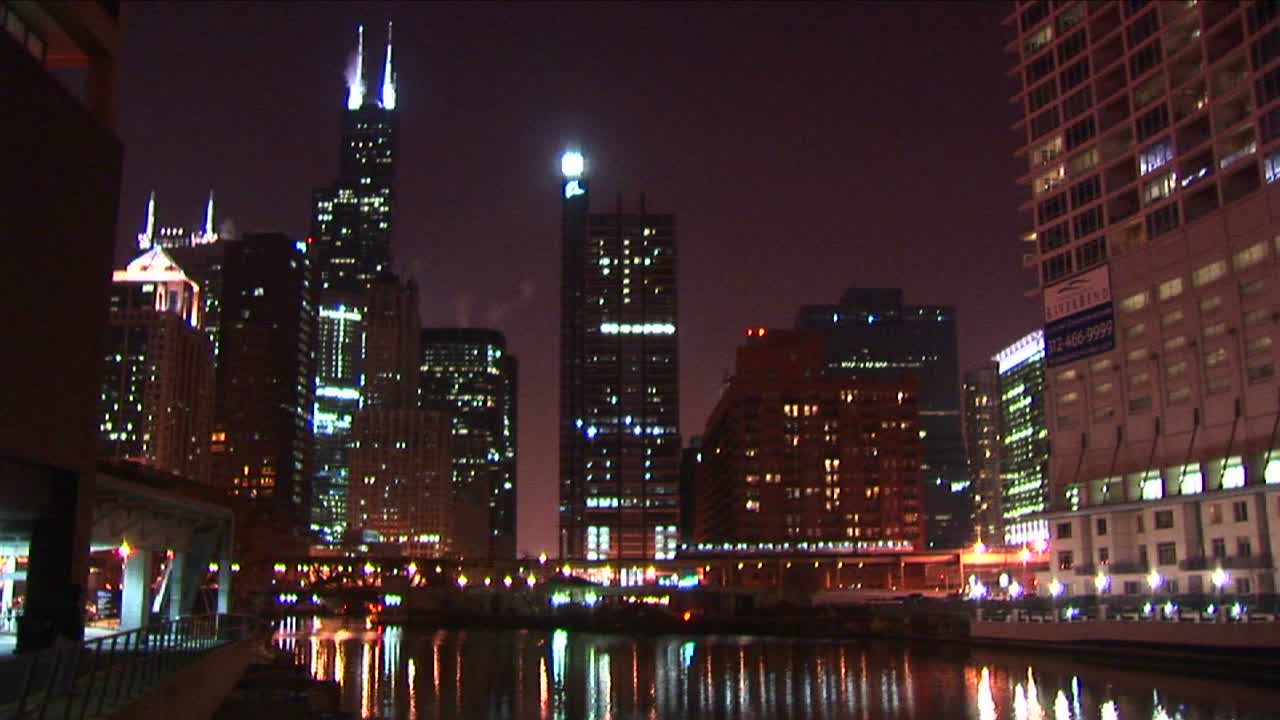 통근열차는 밤에 빛나는 시카고 스카이라인을 천천히 가로질러 움직입니다.