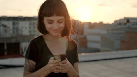 atractiva morena con gadget en el techo al atardecer