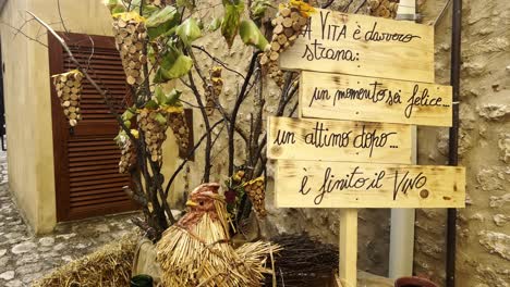 Slogan-for-grape-harvest-festival-of-medieval-Penna-in-Teverina-town-with-decorated-houses-and-streets,-Italy