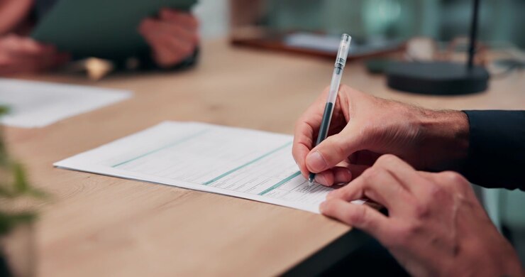 Businessman Signing a Document at an Office Desk