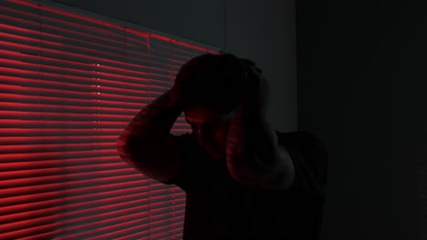 man in distress near red lit window
