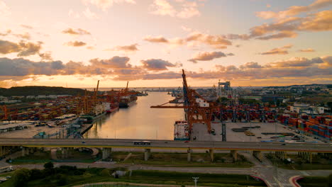 Vehículos-Circulando-Por-Un-Puente-Con-Puerto-Industrial-Al-Fondo-Al-Atardecer-En-Gdynia,-Polonia