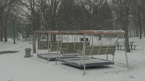 Leere-Bänke-Draußen-Unter-Schnee-Im-Park-Mit-Bäumen