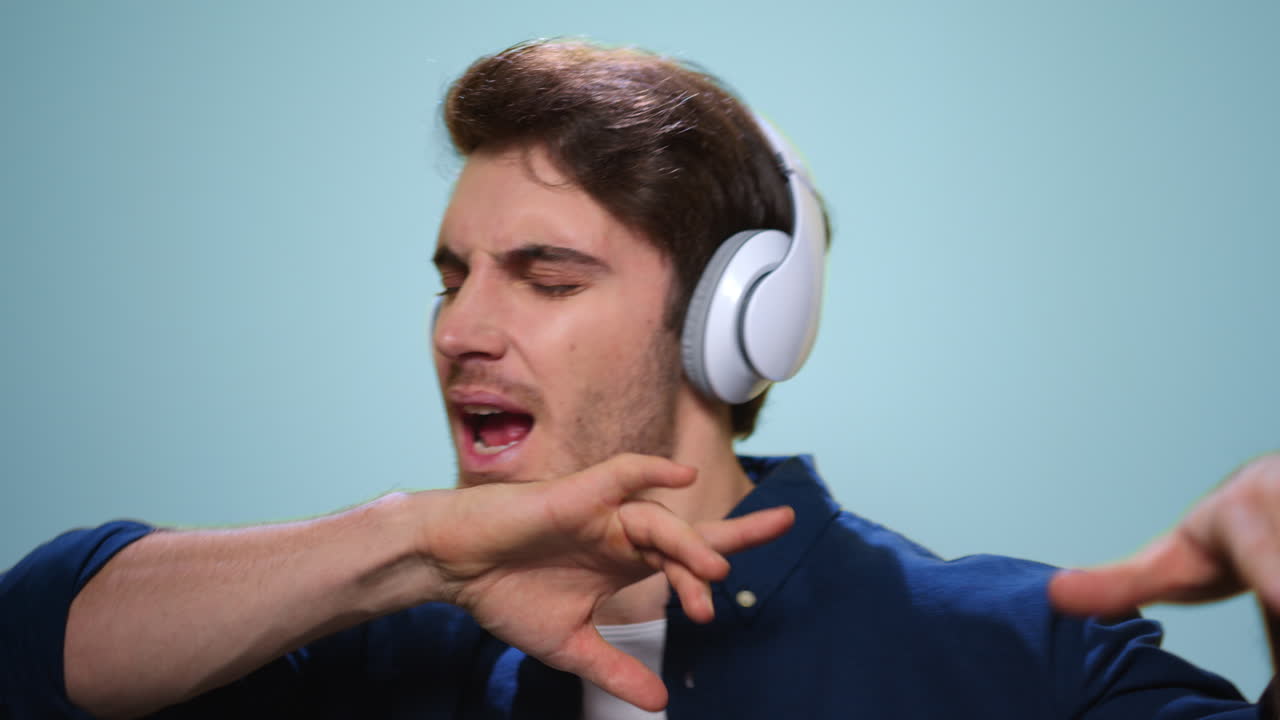 헤드폰을 끼고 있는 잘생긴 남자. 헤드폰으로 음악을 듣는 남자