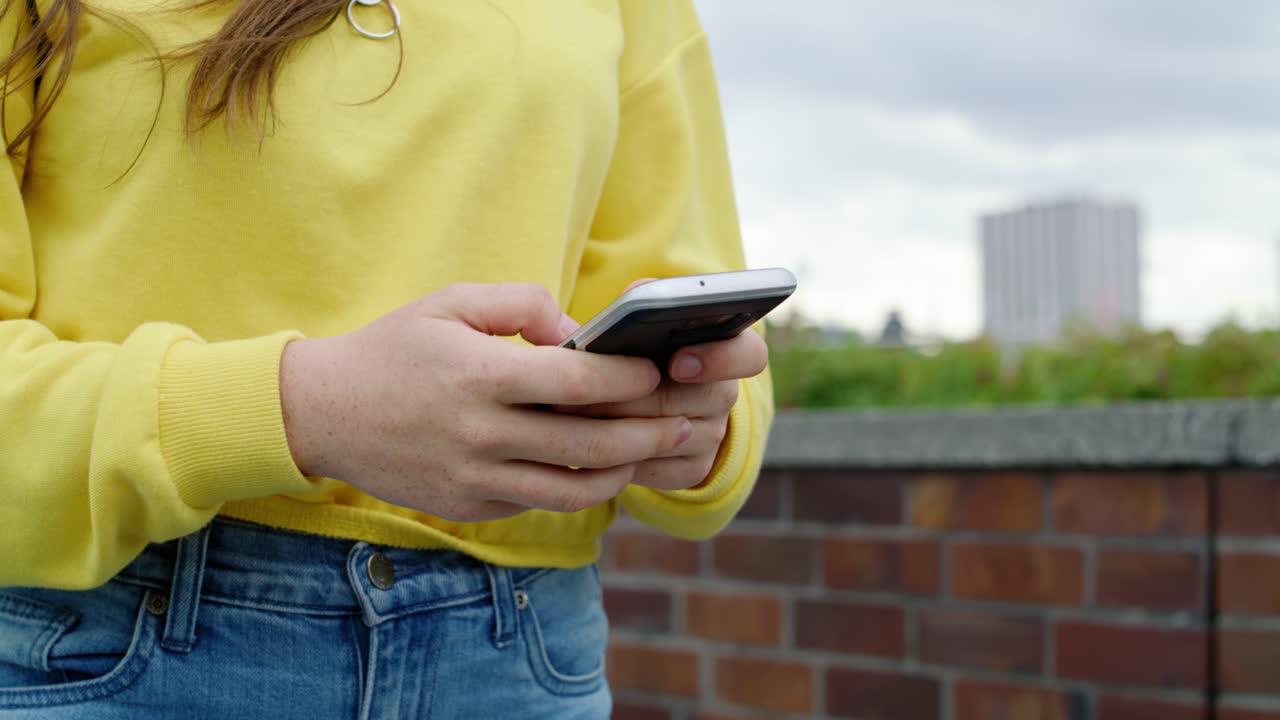 mujer usando teléfono inteligente y caminando por la calle de la ciudad