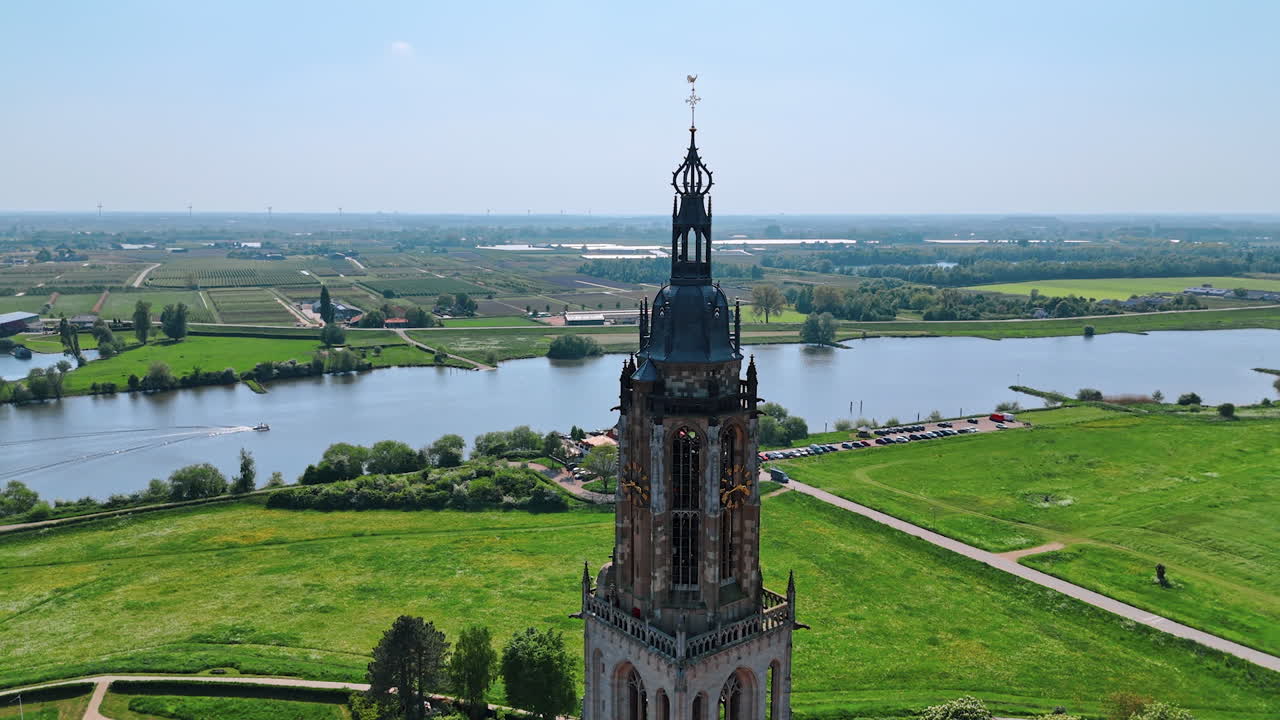 Flight around the top of Church in Rhenen, the Netherlands. View on the beautiful nature, cityscape of the municipality and river on sunny daytime.