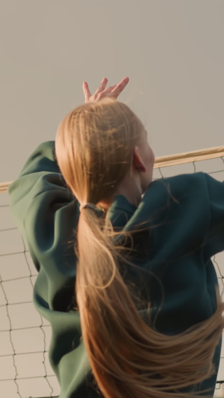 волейболист соревнуется в открытом матче с солнечным светом, отражающимся на сетке, создавая теплое свечение, руки, тянущиеся за мячом в игровой игре, с голубым небом и размытым фоном