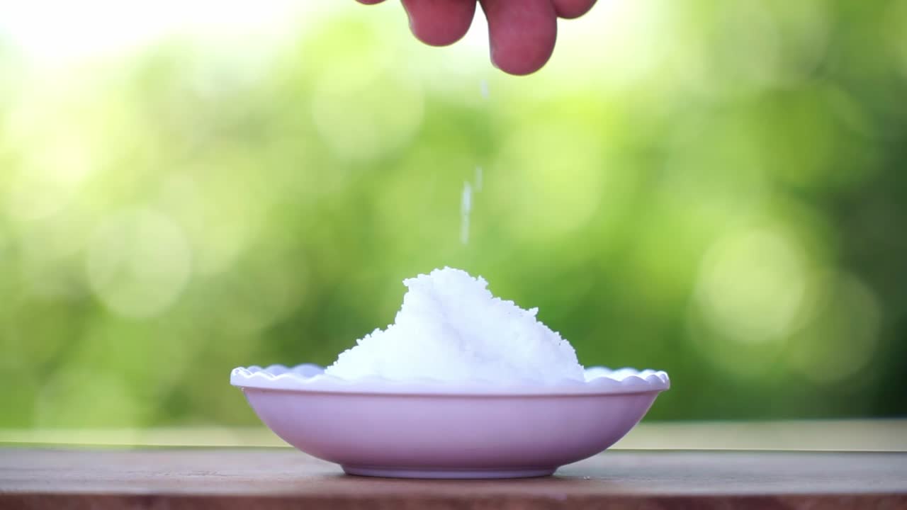 사람들의 손은 그에  크리스탈 소금을 잡고 그것을 부어