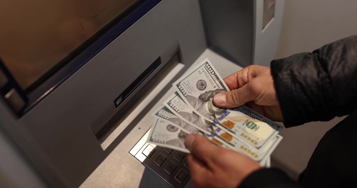 Å telle kontanter ved minibanken avslører gleden ved et vellykket uttak i hjertet av byen.
