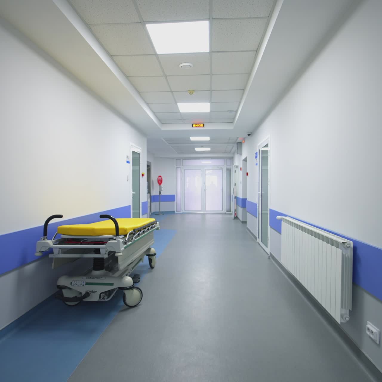 Medical bed in the hospital corridor. Interior of modern hospital with empty long corridor
