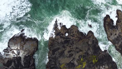 4k 30fps aerial footage of thor's well, spouting horn along the oregon pacific northwest coast - aerial view turquoise blue water, mossy rock, waves crashing -top down flying shot smooth dji drone