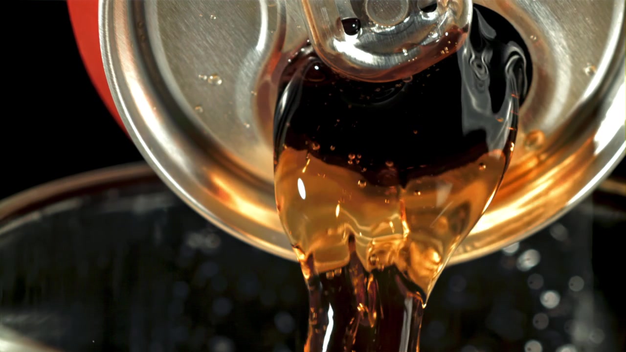Cola frizzante che si versa da una lattina al rallentatore