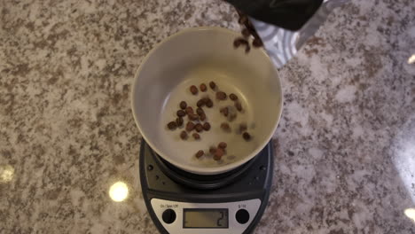 coffee beans being dropped onto food scale in slow motion