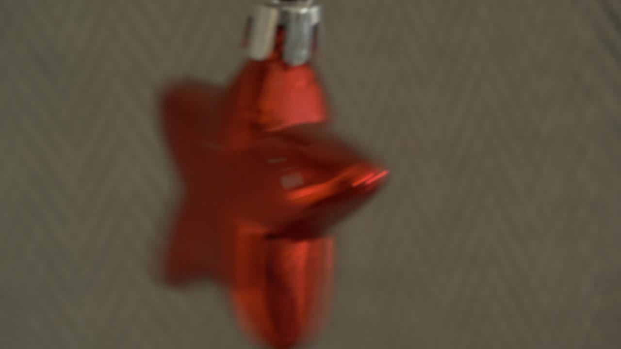 swinging red star being hung and a christmas decoration