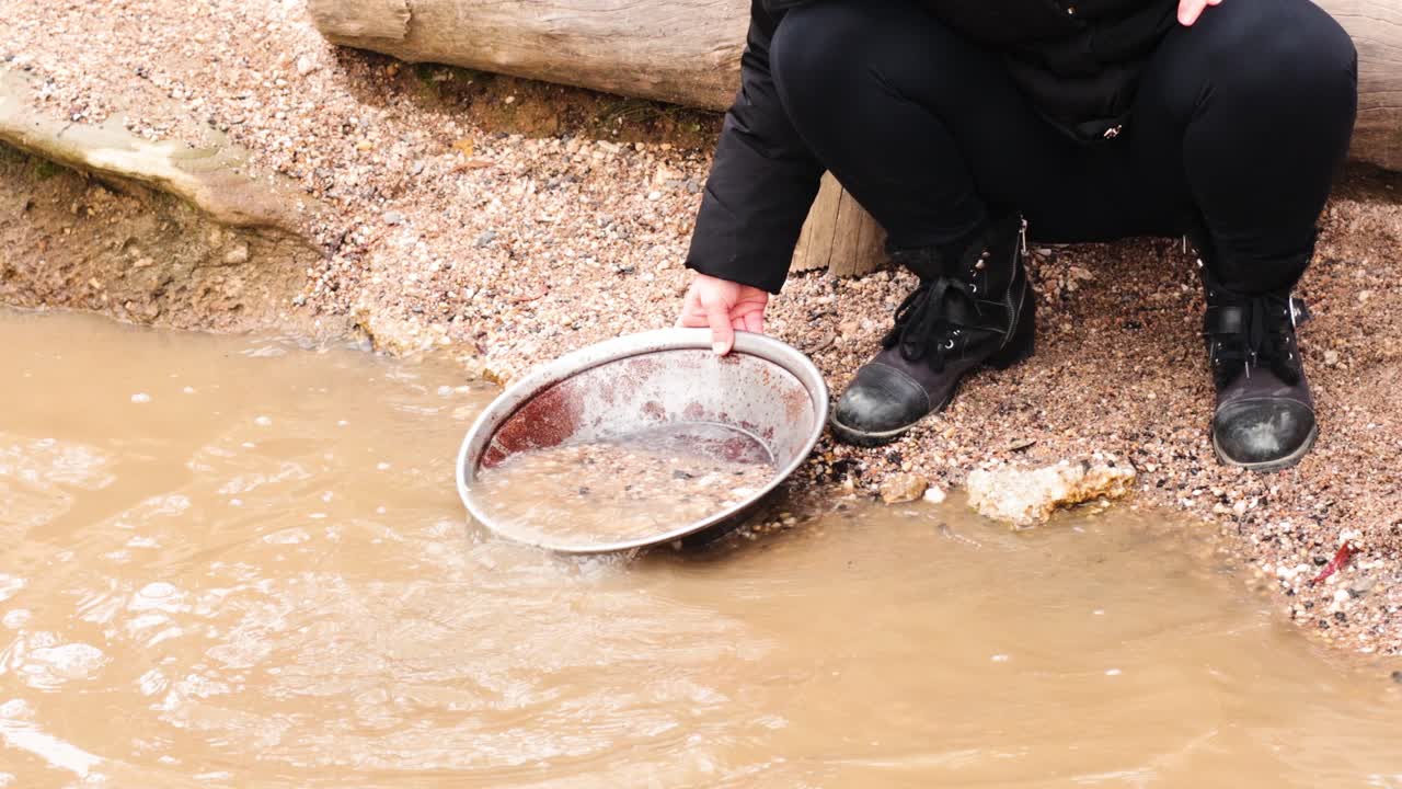 persona buscando oro en aguas fangosas