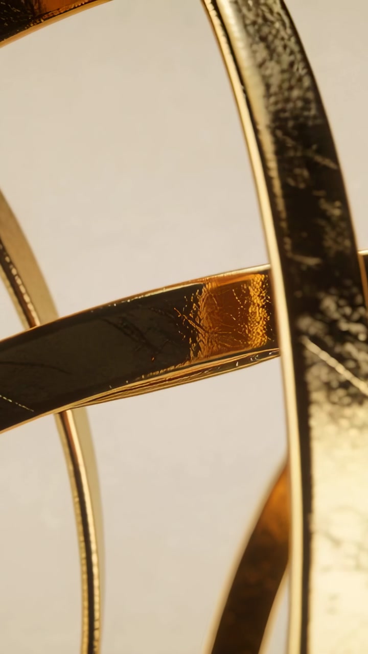 Vertical video: Camera shifting focus sending gold metal bands sliding across set showing scratches