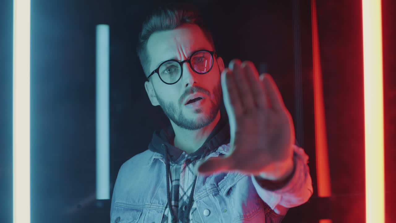 Man in Neon Light with Stop Gesture