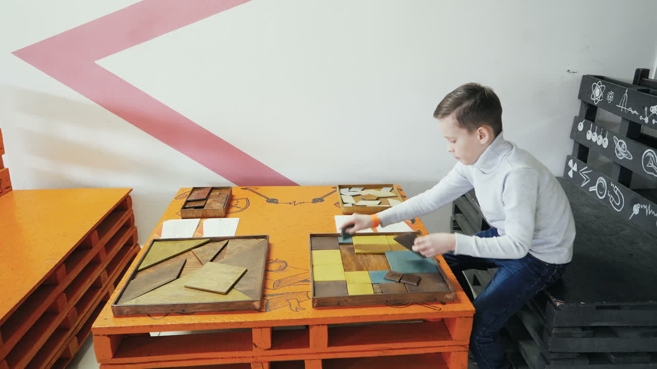 Boy playing with a puzzle of wood. Kid in the scientific center.
