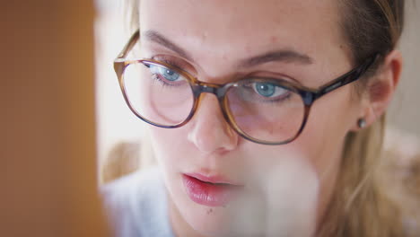 Close-Up-On-Face-Of-Female-Teenage-Artist-Working-Behind-Easel