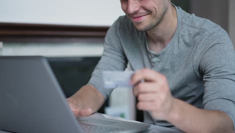 hombre usa tarjeta de crédito para comprar en línea