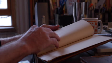 Man-Reading-and-Researching-in-Solitude-in-Quarantine,-Flips-Through-Pages-of-Old-Book