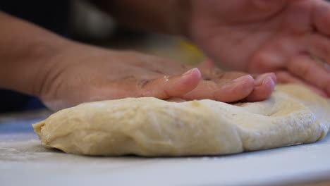 hand kneading dough for rolls, bread, pizza or pastries - isolated close up in slow motion