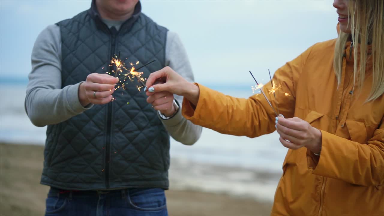 Couple and child enjoying sparklers on the beach