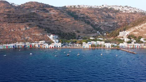 Wide-aerial-pull-back-of-Klima-port-village-in-the-hilly-Milos-island,-Europe