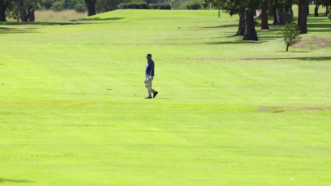 골퍼가 이 많은 골프 코스를 가로질러 걸어가고 있다