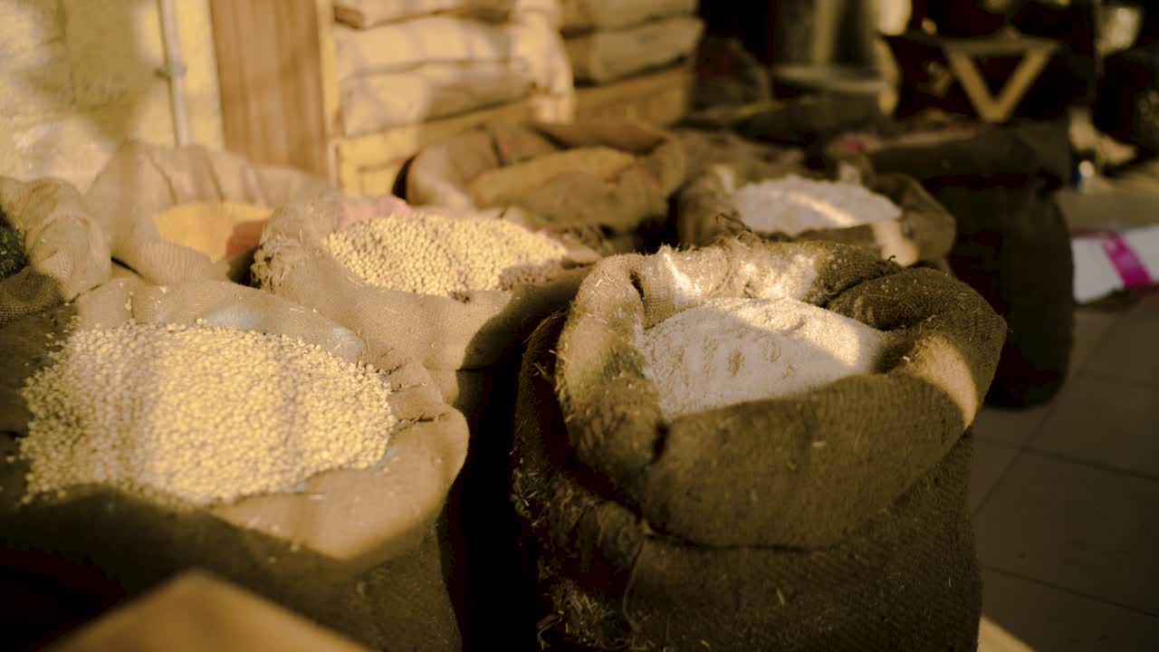 Sacks filled with different grains and flour displayed in a traditional market shop