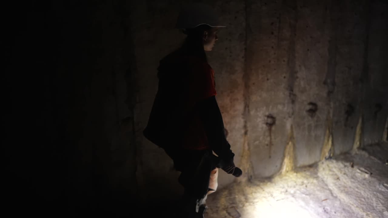 mujer explorando un oscuro túnel subterráneo