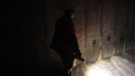 woman exploring a dark underground tunnel