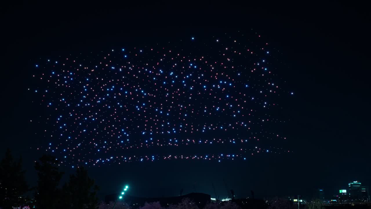 Hundreds of sparkling blue drones in cloud illuminate the night sky above Ttukseom Hangang River Park in Gwangjin-gu, Seoul during Drone Light Show