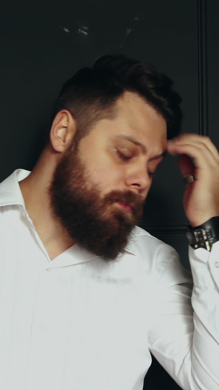 Bearded man in studio. Young handsome bearded man on serious face in studio Vertical video