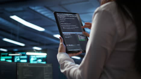 Close-up-of-woman-doing-maintenance-in-server-room-using-tablet