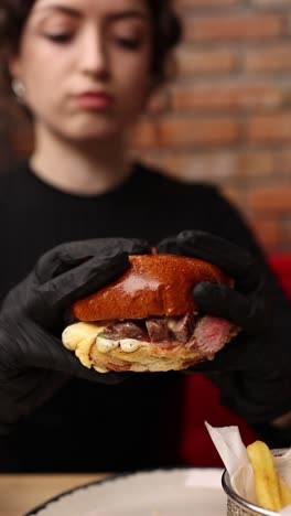 mujer comiendo una deliciosa hamburguesa de carne en un restaurante