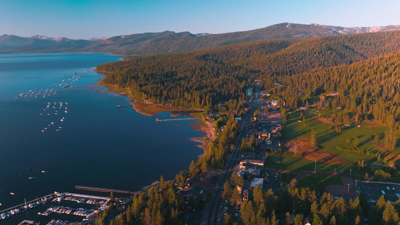 Stunning scenery of beautiful Lake Tahoe on sunny warm day. Waterfront with all the necessary infrastructure and blue water of lake with numerous boats. Top view.