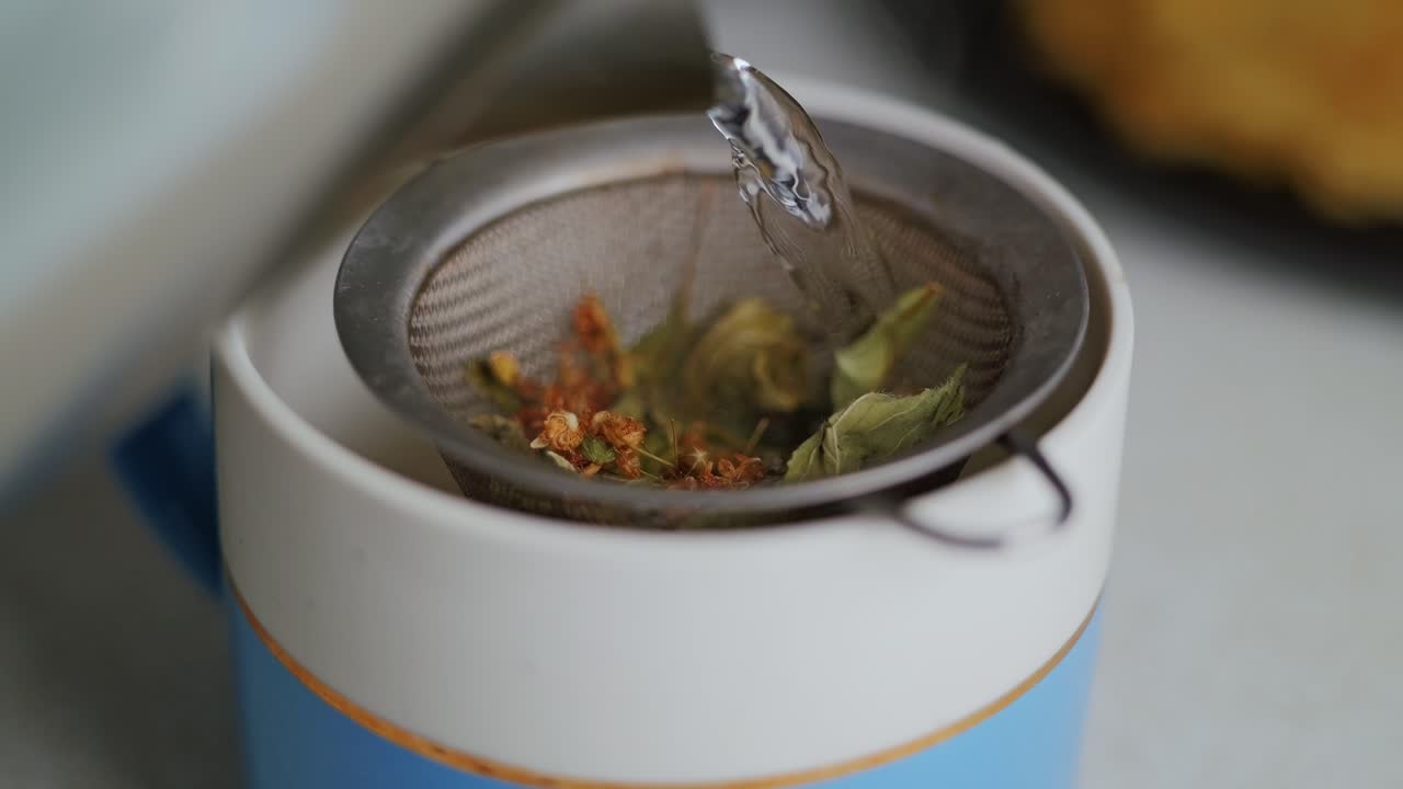 Close-up of herbal tea infusion with loose leaves steeping in a mesh strainer