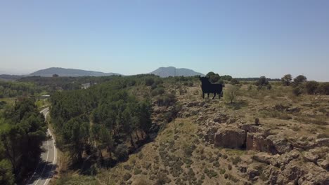 Aerial-shot-of-a-big-Spanish-bull-sign-on-the-top-of-a-hill