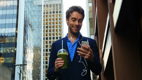 Businessman-talking-on-mobile-phone-while-having-juice