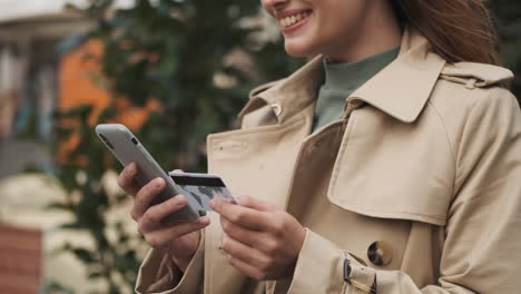 estudiante caucásica haciendo compras en línea en el teléfono inteligente al aire libre.