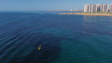 Vista-Aérea-De-La-Pesca-En-Kayak-En-El-Paisaje-Marino,-Vista-De-Drones-De-Pesca-Con-Curricán