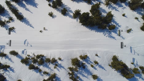 un telesilla con asientos vistos desde arriba, filmado con un dron