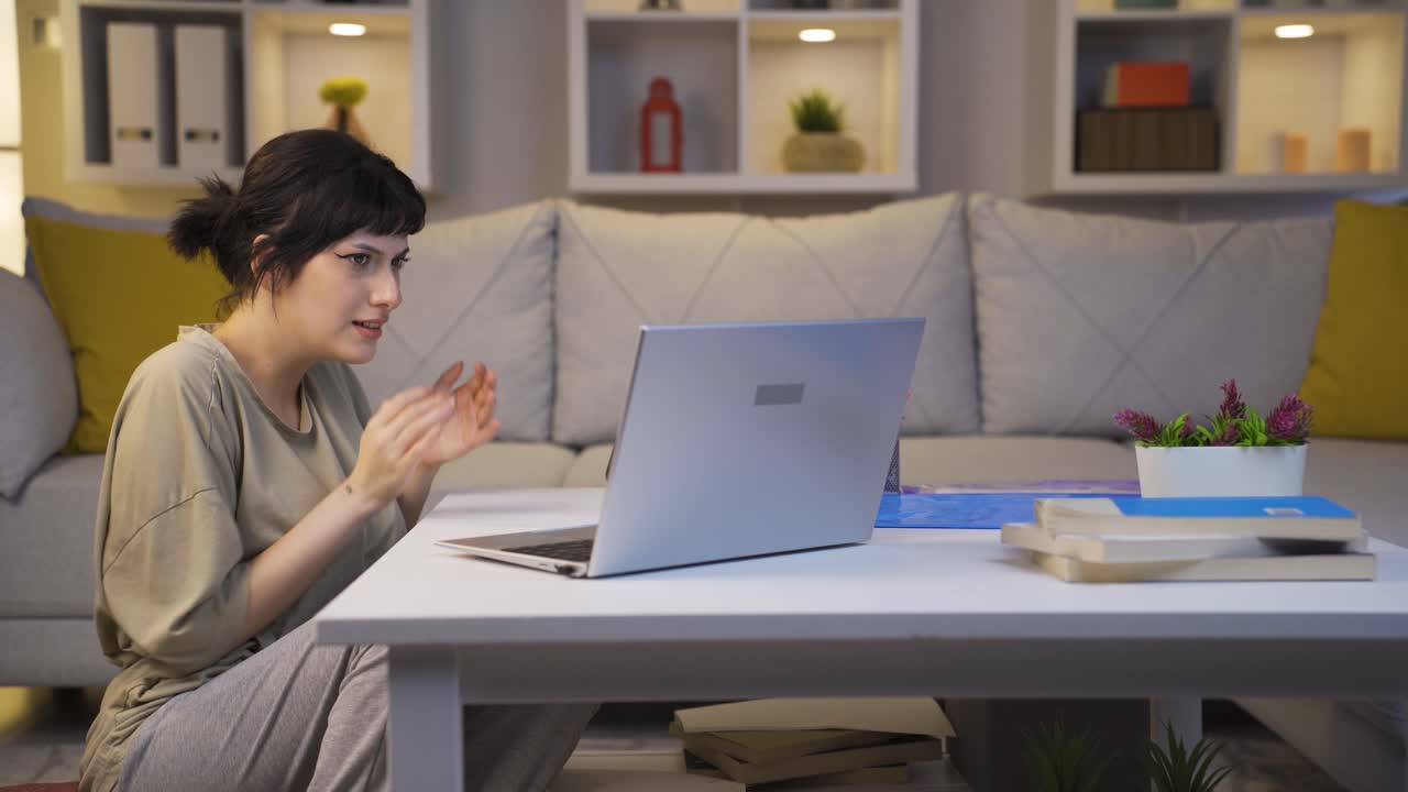 젊은 여성이 밤에 노트북에서 공포 영화를 보고 있습니다. 젊은 여성은 겁에 질려 있고 긴장합니다.