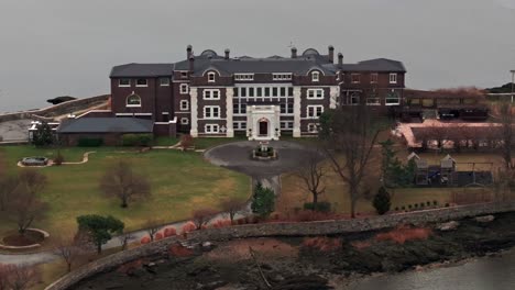 An-aerial-view-of-a-huge-mansion-on-a-small-island-on-a-cloudy-day