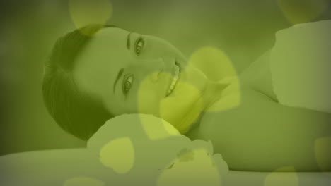 smiling woman relaxing with green heart-shaped animation over her