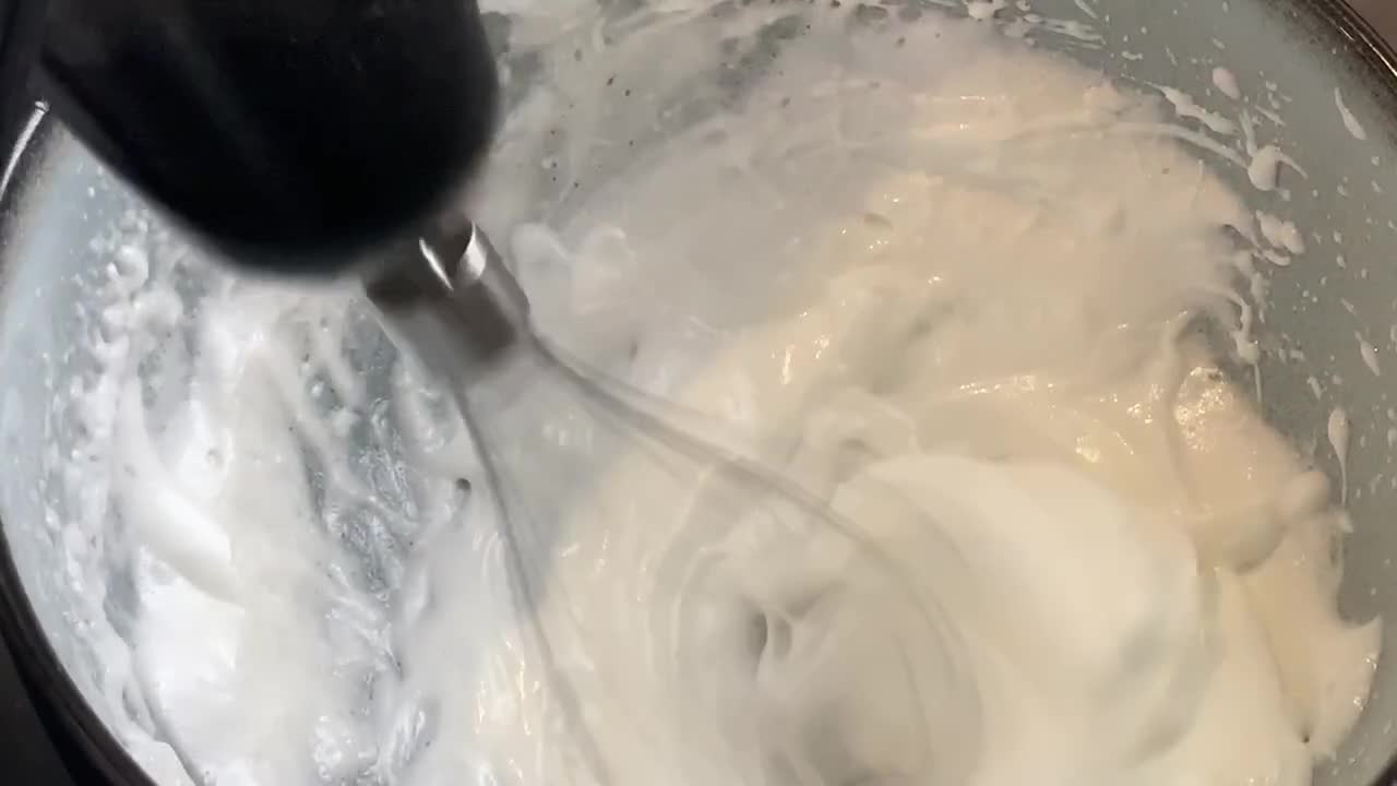 Whipping egg whites to create a thick and frothy consistency.