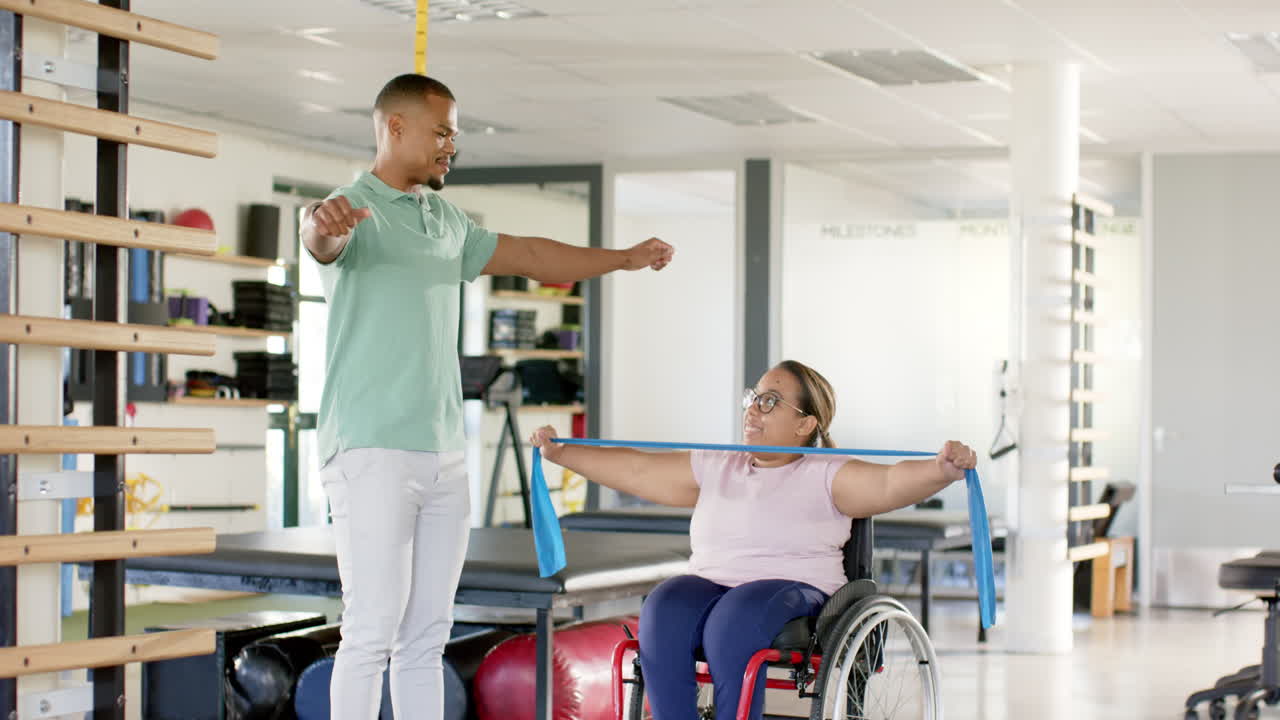 Rehabilitation, therapist using resistance bands assisting woman with paraplegia in wheelchair